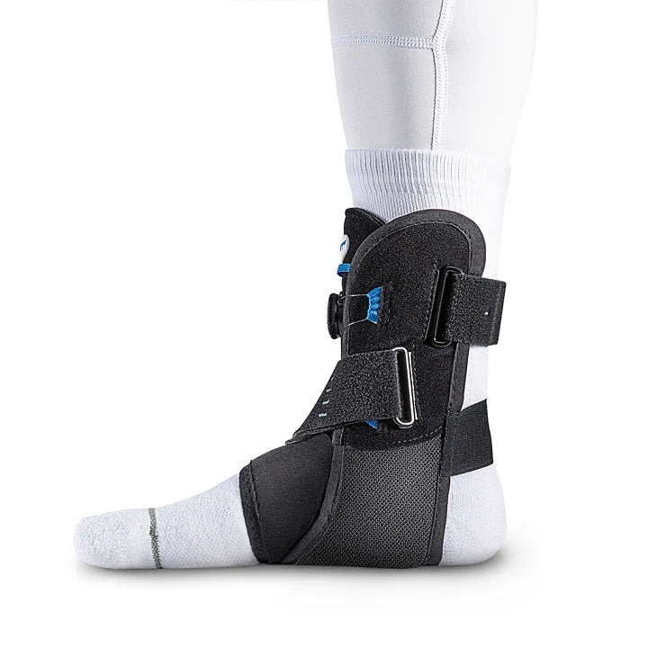 Black Aircast AirSport Plus ankle support brace worn on a person's left foot and white sock against a plain white background.