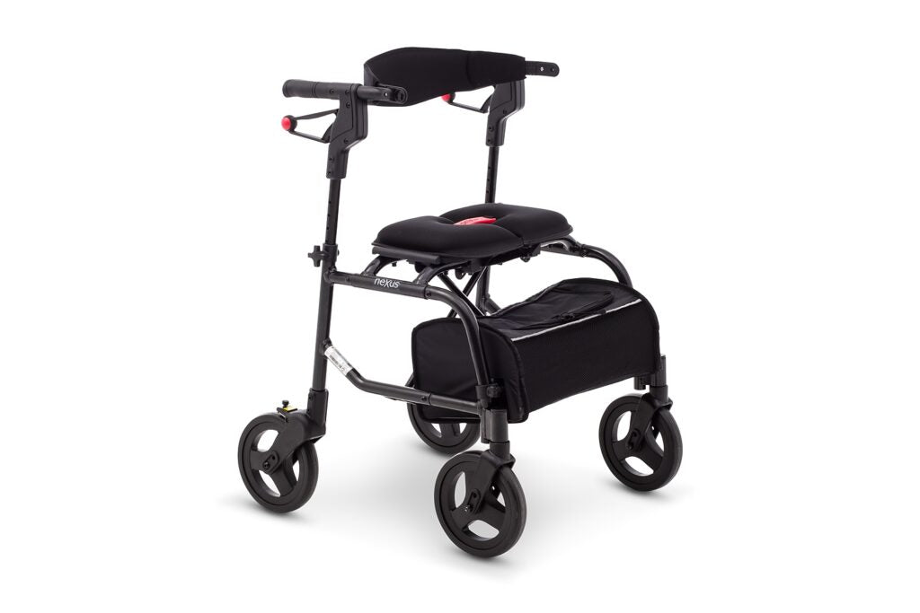 Side profile of the Human Care NeXus 3 Rollator in black, showcasing the sleek frame, large wheels, and the spacious soft storage basket.