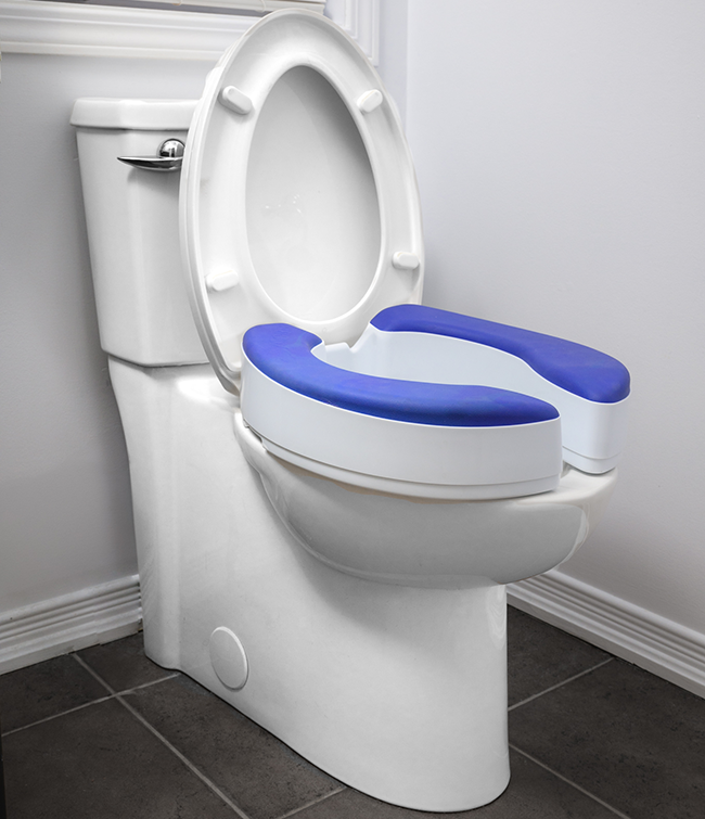 White raised toilet seat riser with blue padded seat cushion installed on a toilet bowl