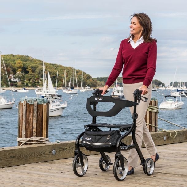 Red Drive Nitro Sprint rollator walker with four wheels, black padded seat, backrest, and front storage bag on a white background.