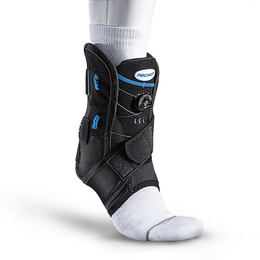 Three-quarter view of a black Aircast AirSport Plus ankle support brace with blue accents worn over a white sock against a plain white background.