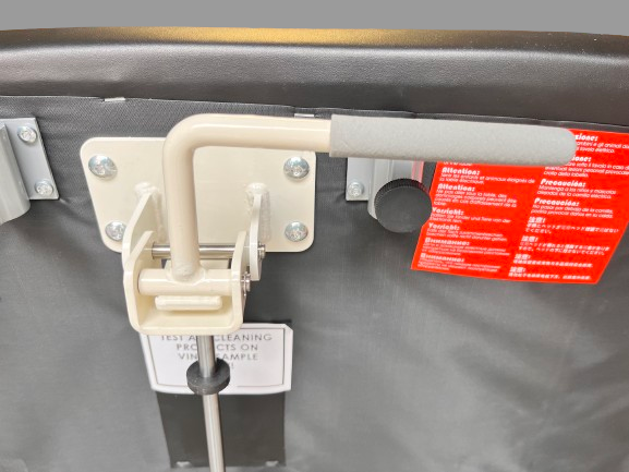 Detailed close-up of the foot pedal switch mechanism mounted on the frame of the 2-section electric treatment table for hands-free height adjustment.