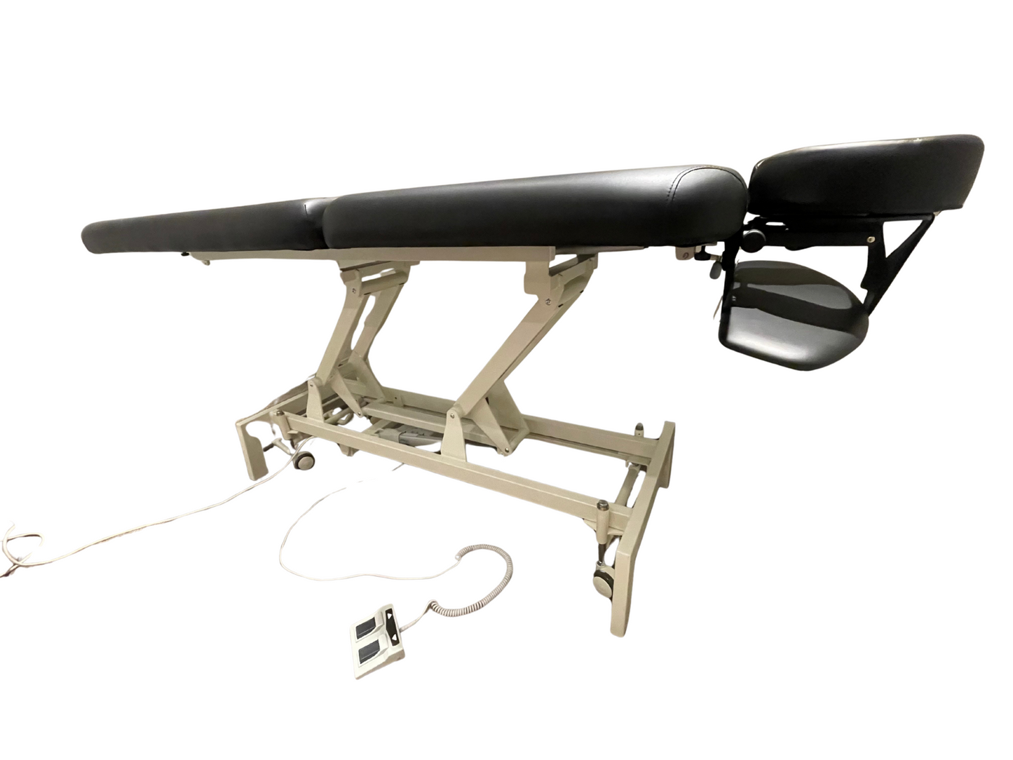 Side profile view of the flat black 2-section electric height control treatment table, showcasing its sturdy white steel scissor-lift frame and foot control unit.