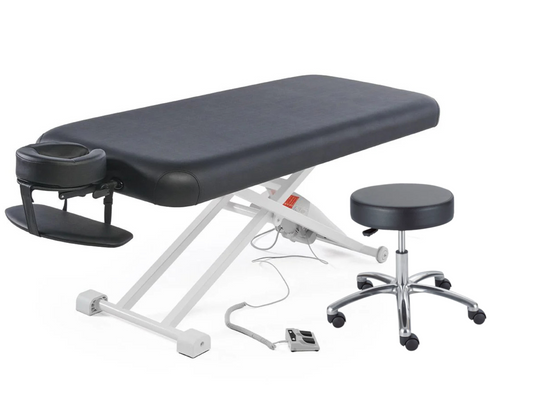 Black flat top electric massage table with attached face cradle, foot pedal control, and matching black hydraulic rolling stool on a white background.