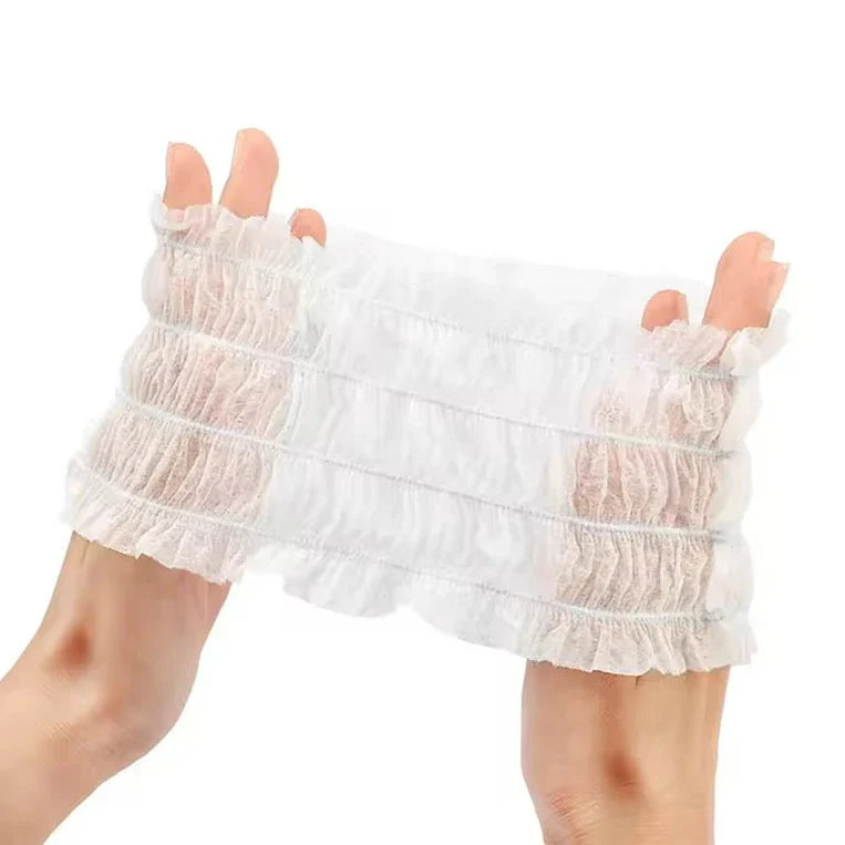 Two hands stretching a white elastic disposable non-woven spa headband designed for facials, skincare, and makeup application.