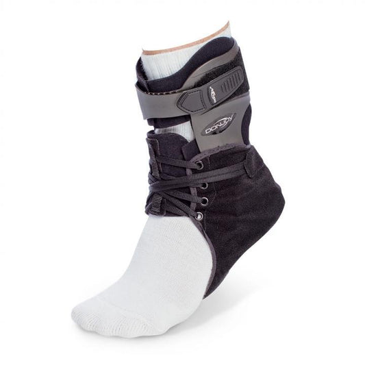 DonJoy Velocity ES Extra Support Ankle Brace worn over a white sock, displaying its rigid molded calf shell, speed-lacing closure, and anatomical ankle support design.