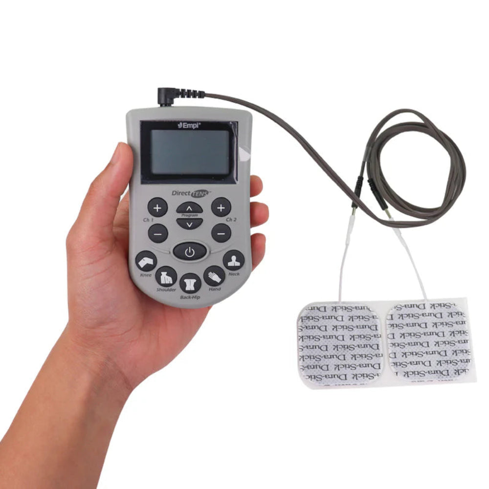 A person holding the compact Empi Direct TENS device next to a set of four self-adhesive square electrode pads.