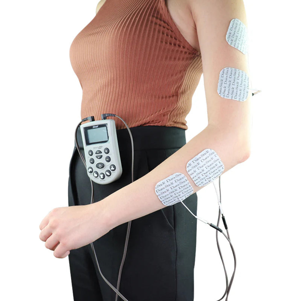 A person using the Empi Direct TENS unit on their forearm, demonstrating the electrode pad placement for localized pain management.