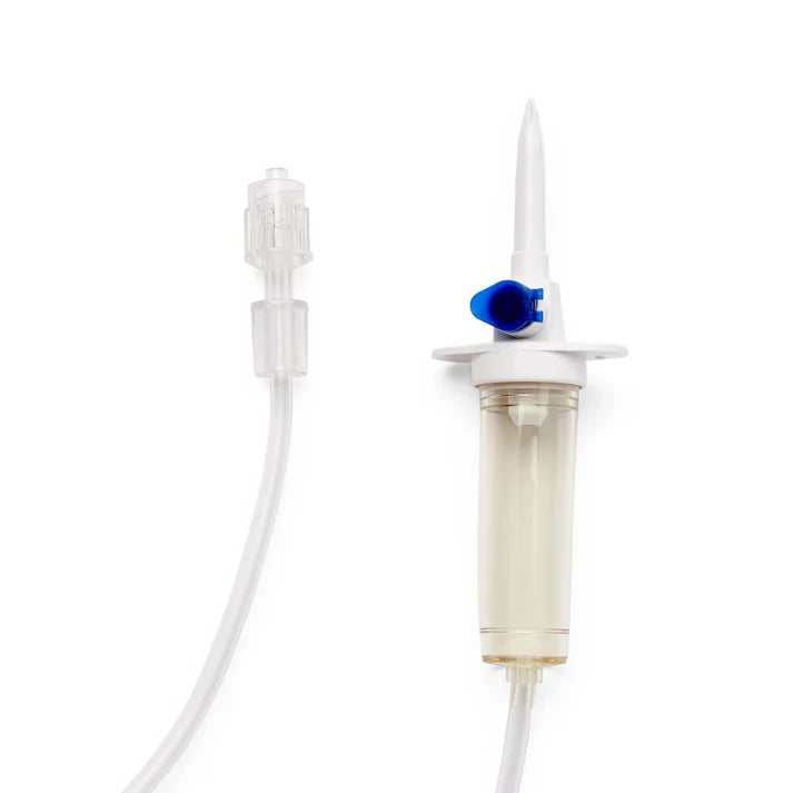 Close-up view of the vented drip chamber, clear piercing spike, and blue flow regulator cap on an IV administration tubing set.
