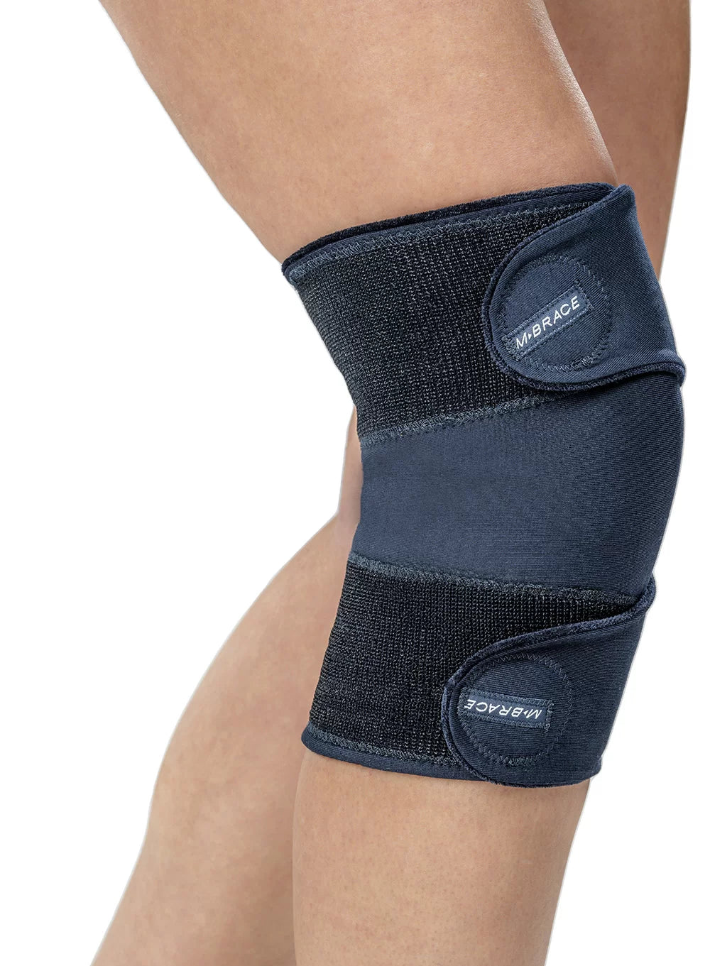 Navy blue M-Brace compression knee support sleeve worn on a person's leg with top and bottom adjustable straps.