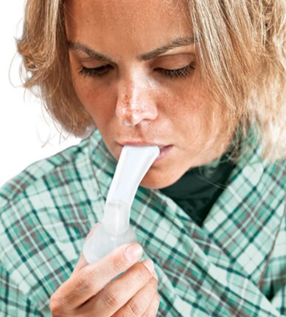 Woman using a breathing device with a white background