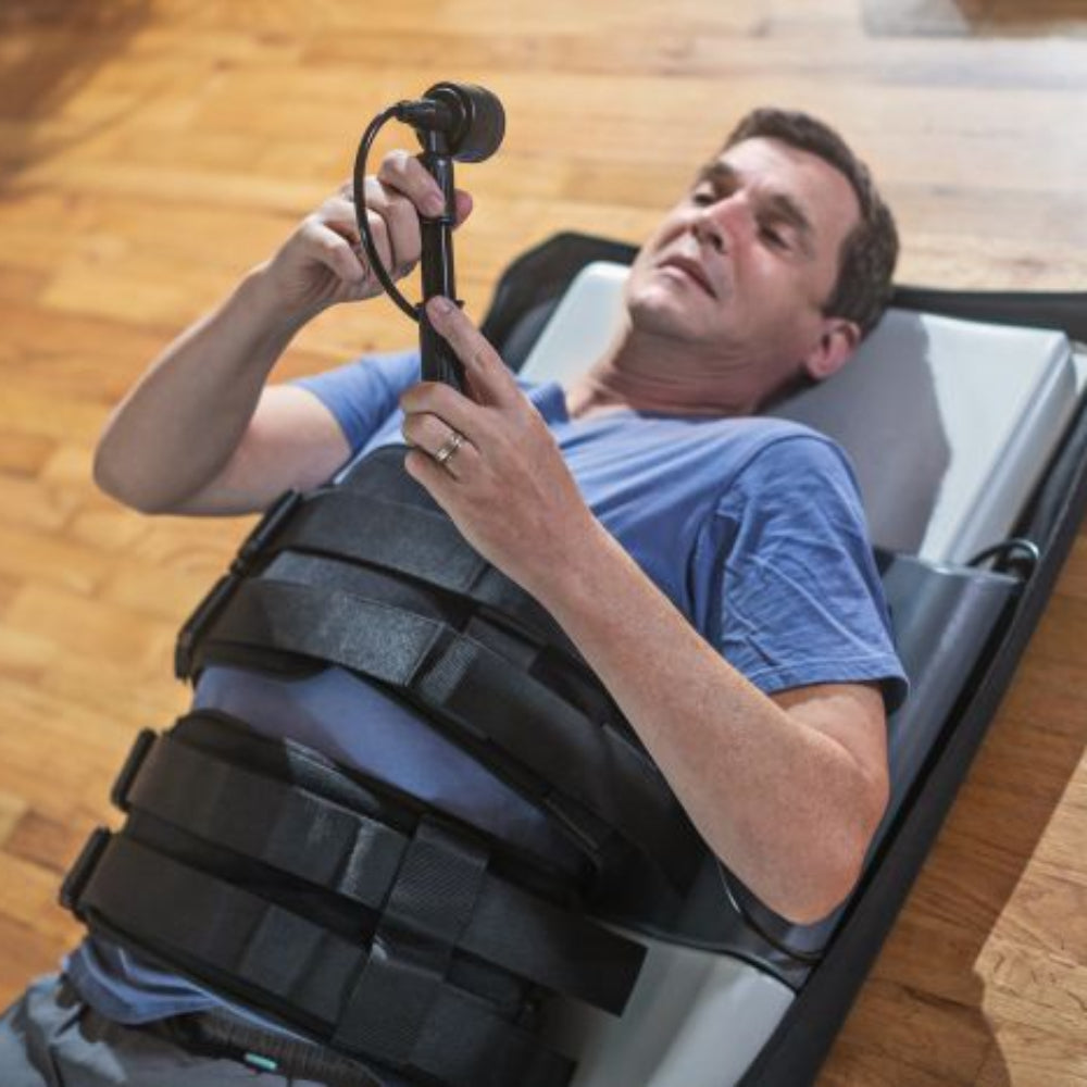 A close-up of a user securing the non-slip harnesses of the Saunders device, emphasizing the ease of setup for independent home use.