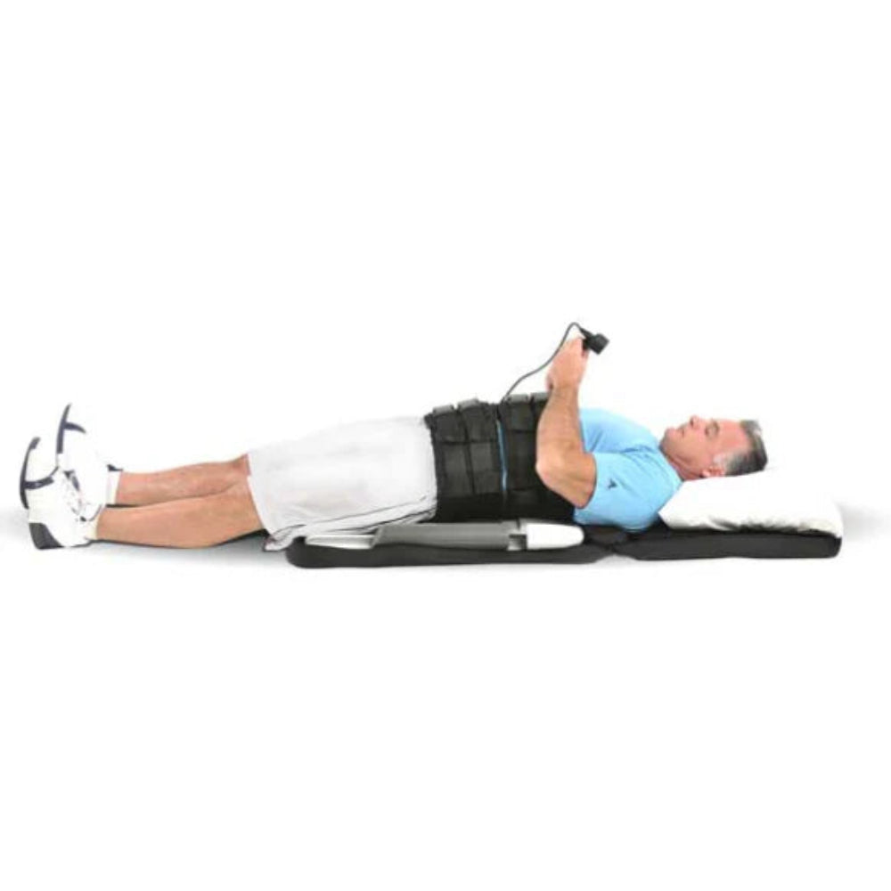 A user lying on a yoga mat while using the Saunders Lumbar device, illustrating the correct supine positioning for targeted spinal stretching.