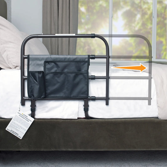 Black Stander Wonder Bed Rail safety guard with attached organizer pouch installed on a mattress setup, featuring an orange extending arrow.