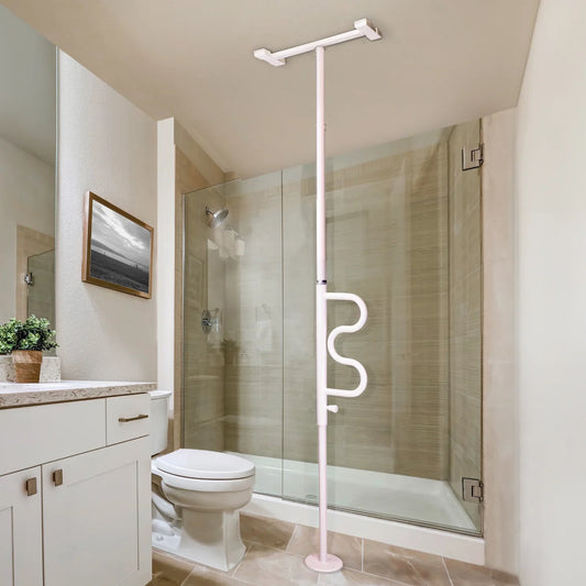 White Stander Wonder Pole tension-mounted floor-to-ceiling transfer pole with ergonomic grab handle installed in a bathroom between a toilet and glass shower door.