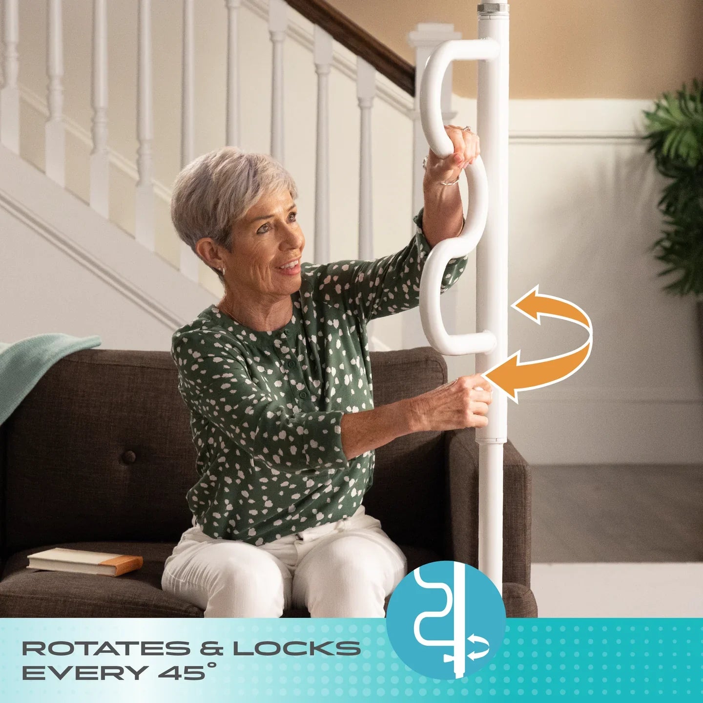 Senior woman sitting on a couch reaching for a white Stander Wonder Pole transfer pole with ergonomic handle, featuring an orange curved arrow and a teal bottom banner reading ROTATES & LOCKS EVERY 45°.