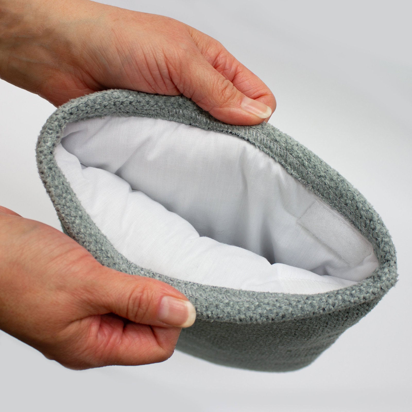 A person wearing the Therabath insulated mitt over a gloved hand, demonstrating the therapeutic "heat window" created to soothe stiff joints.