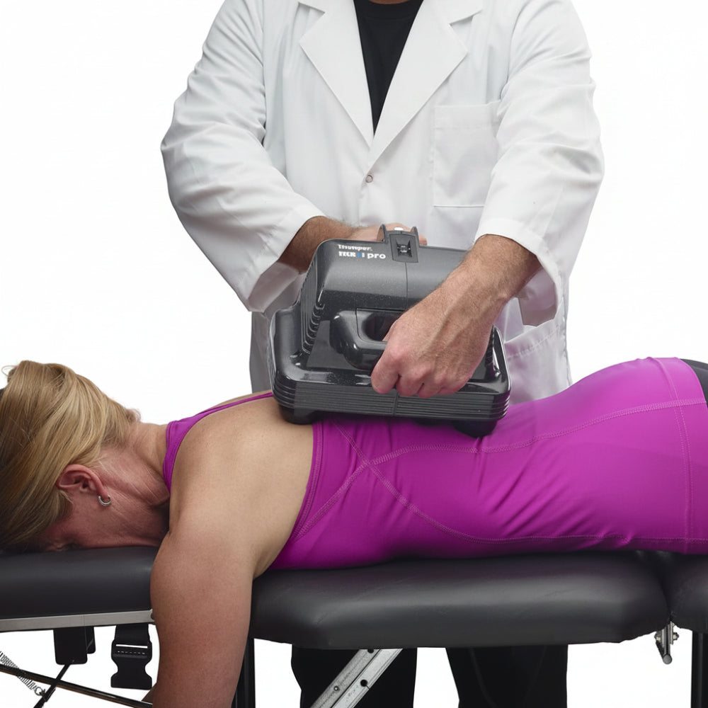 A healthcare professional applying the Thumper Maxi Pro to a patient's back to release stubborn muscle knots and tension.