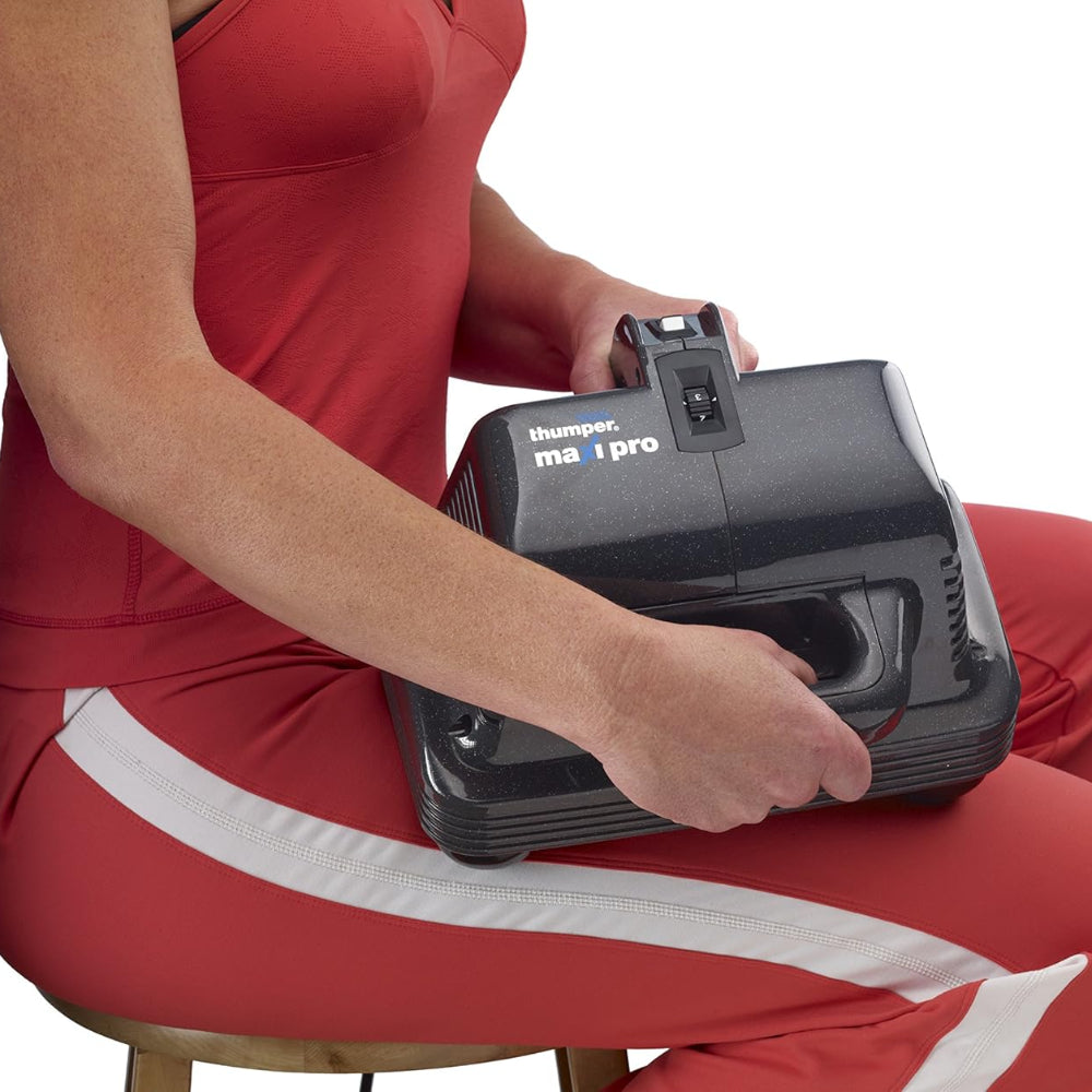 The Thumper Maxi Pro being used on the large muscle groups of the leg, demonstrating its deep-tissue therapeutic capabilities.