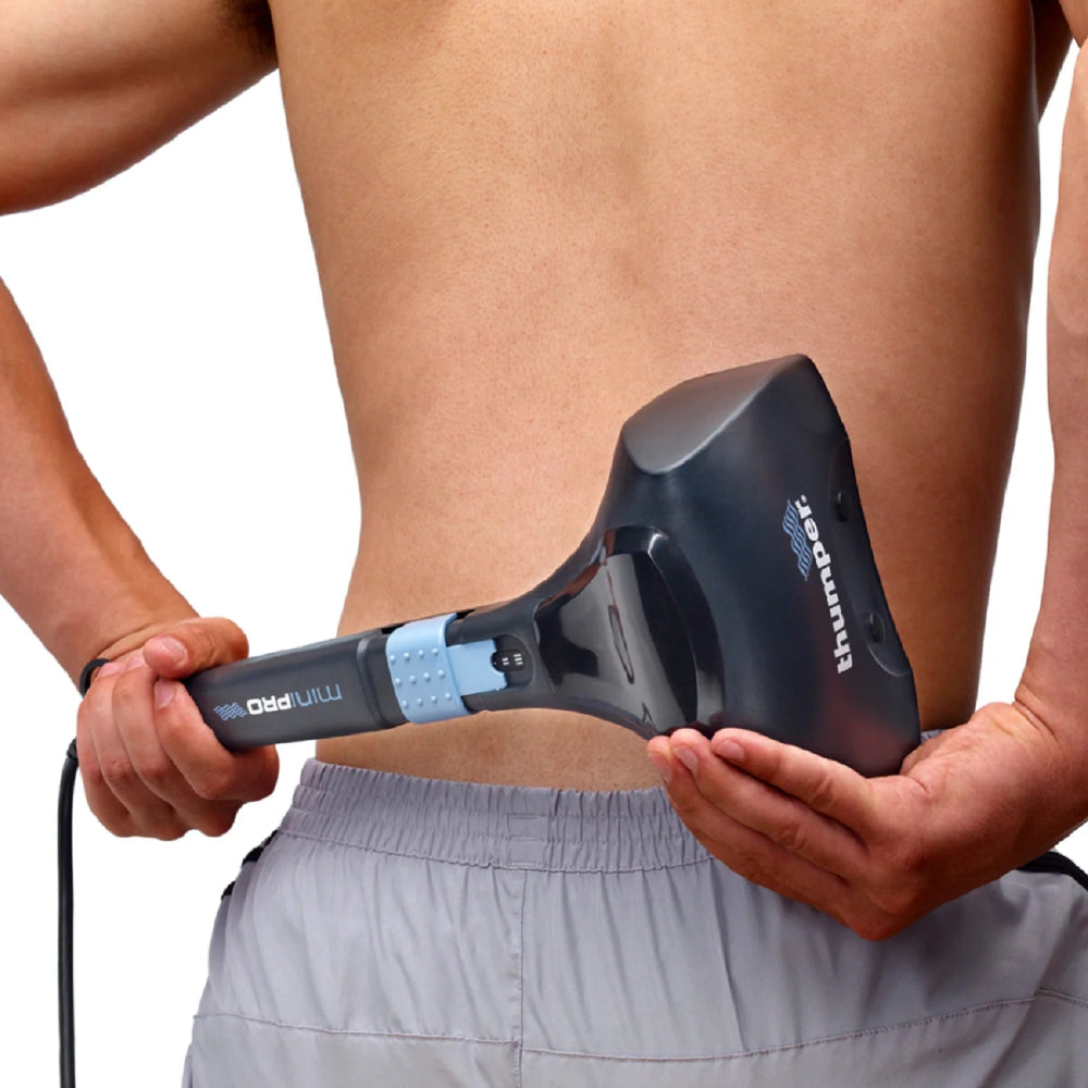 The massager being applied to the lower back of a standing user, showing the versatility of the tool.