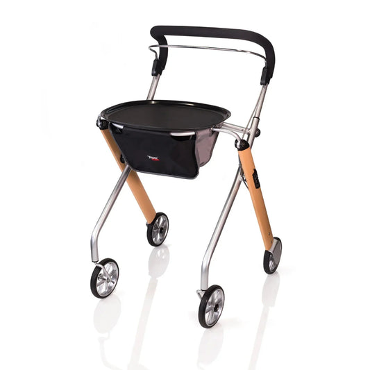 Standalone angled view of the Trust Care Let's Go Indoor Rollator in beech and silver, featuring a narrow design, full-length padded handle, and a removable tray for transporting meals.