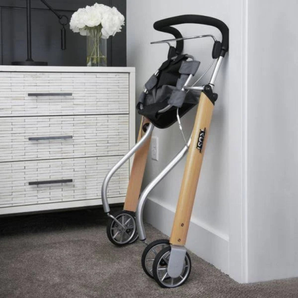 A person folding the Let's Go Indoor Rollator, demonstrating how the slim frame collapses for discrete storage behind furniture or in closets.