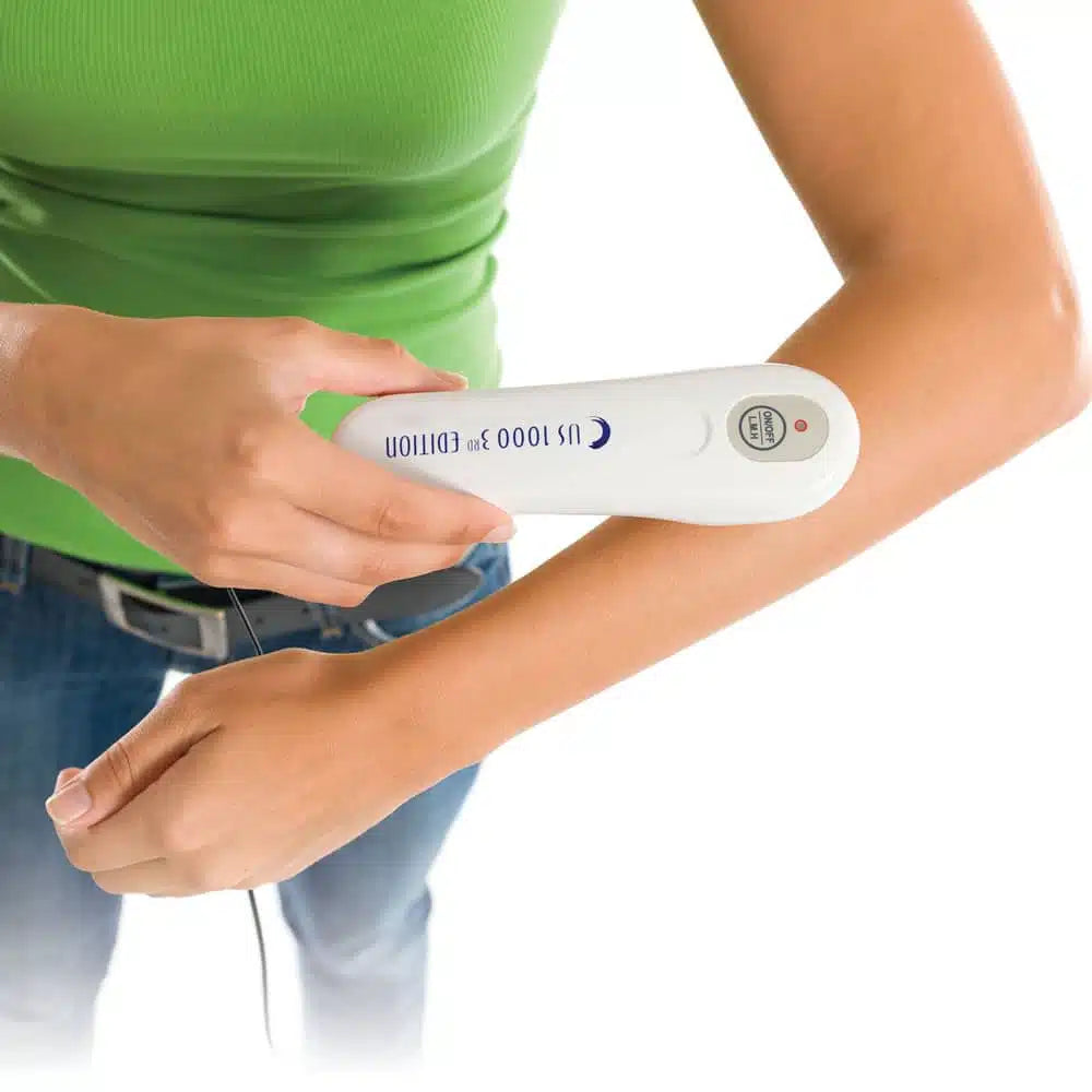 A user applying the US 1000 ultrasound device to the hand area to manage joint pain and improve mobility through ultrasonic vibration.