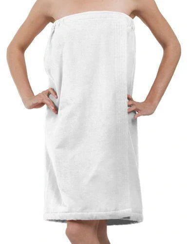 Woman standing hands-on-hips wearing a white terry velour spa shower wrap towel on a plain white background.