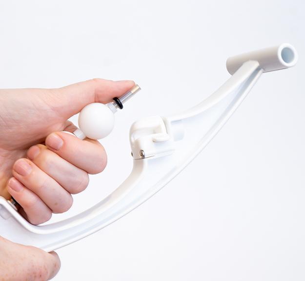 A demonstration shot showing the Armaid tool being used to apply deep tissue pressure to the forearm, highlighting the lever-based design for effective self-treatment.