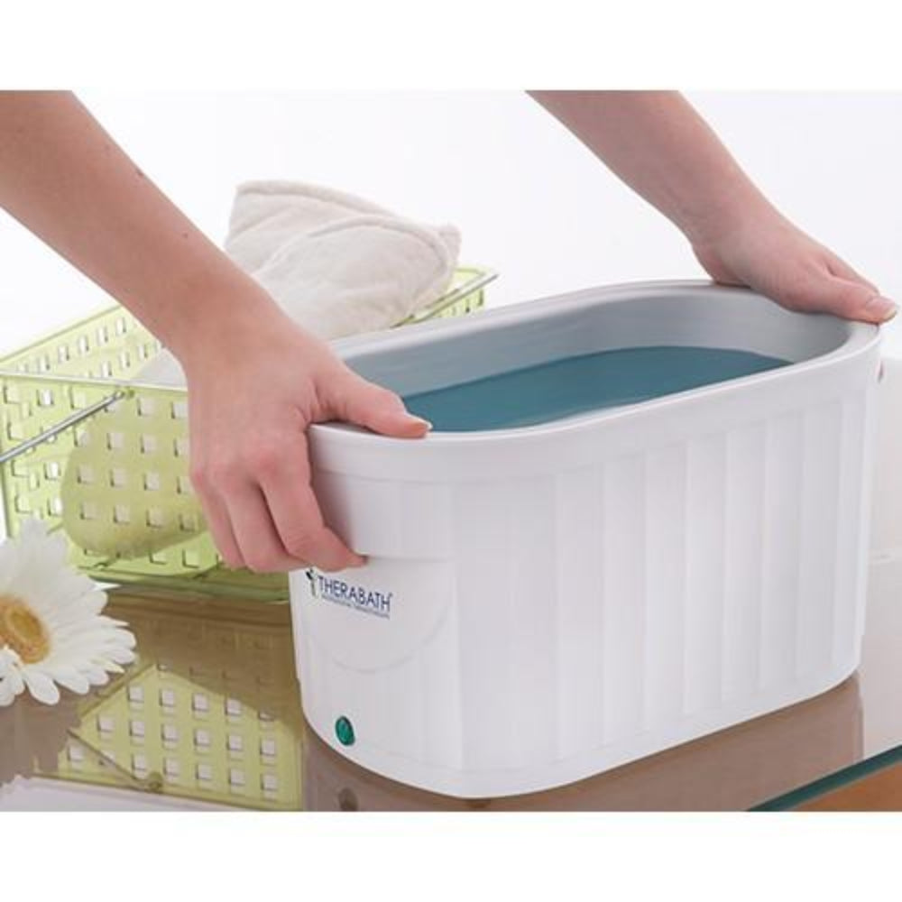 A lifestyle image showing a hand being dipped into the Therabath paraffin unit, demonstrating the effective application of warm wax for joint pain and skin softening.